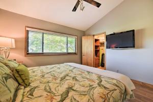 a bedroom with a bed and a flat screen tv at Stunning South Maui Condo with Lanai by Beach! in Kihei