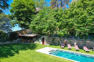 a yard with lounge chairs and a swimming pool at Relais Villino Rubini in Brunate