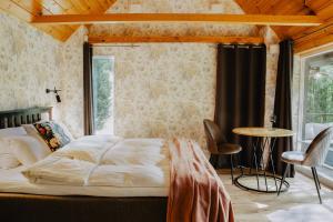 una camera da letto con un letto, un tavolo e delle sedie di Atokampis Boutique SPA & Resort a Anglininkai