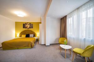 um quarto de hotel com uma cama, uma mesa e cadeiras em Hotel Rivera em Dobrich
