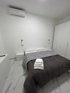 Un dormitorio con una cama con dos toallas encima. en LAVINAIO'S HOUSE, en Nápoles