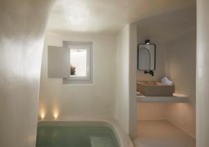 a bathroom with a bath tub and a window at Atoles Retreat in Imerovigli