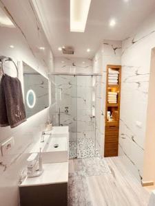 a white bathroom with a shower and a sink at Villa Azure in Palasë