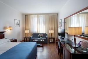 Habitación de hotel con cama y sofá en Starhotels Excelsior, en Bolonia