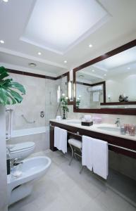 uma casa de banho com um lavatório, um WC e uma banheira em Starhotels Excelsior em Bolonha