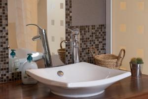 - un lavabo blanc sur un comptoir dans la salle de bains dans l'établissement Maison - Le Terra Verde - Terrasse, à Haguenau