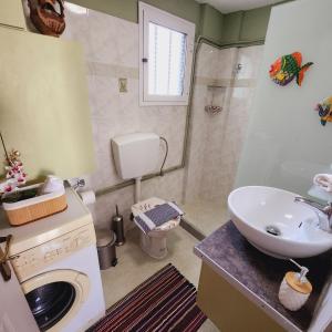 a bathroom with a sink and a washing machine at Luxury Loft Apartment Sofia in Patra