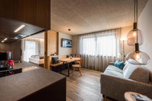 cocina y sala de estar con sofá y mesa en Small Luxury Apartments Lausa en Valdaora