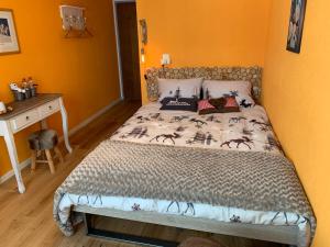 Łóżko w pokoju z biurkiem i łóżkiem w obiekcie Vent_du_Nord w mieście Tramelan
