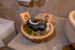 a basket of bottles of soap and oils on a bathroom counter at Hidden Cave Hotel in Göreme