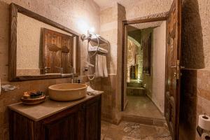 a bathroom with a sink and a mirror at Hidden Cave Hotel in Göreme