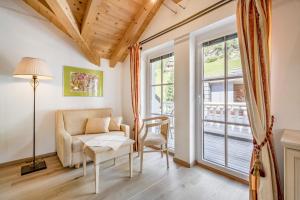 salon z kanapą, stołem i oknem w obiekcie Villa Castelbell w Solden