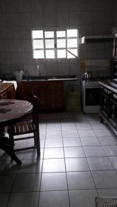 uma cozinha com piso em azulejo, uma mesa e um fogão em Guest Hostel 2 Marli's em Bonito