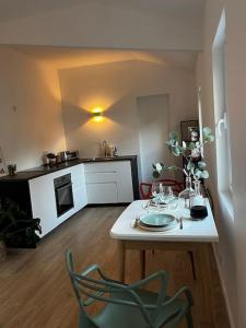 een keuken met een tafel met wijnglazen erop bij Brand new Tiny House w garden in Saint-Cloud