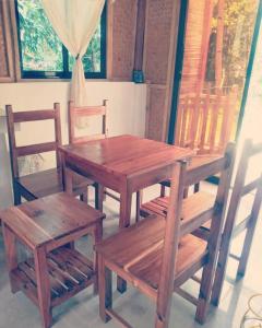 a wooden table and two chairs and a table and bench at The Beach House at Dipnay San Fernando, El Nido in El Nido