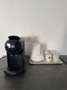 a coffee maker and some cups on a table at Brand new Tiny House w garden in Saint-Cloud