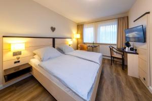 a hotel room with a large bed and a desk at Landgasthof Struckum in Struckum