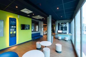 a room with two tables and a green wall at ibis budget Lyon Villeurbanne in Villeurbanne