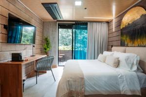 1 dormitorio con cama, escritorio y ventana en Living by Armoniko, en Medellín