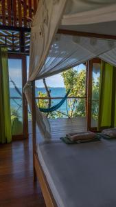 a bedroom with a bed with a view of the ocean at Araya Dive Resort Togean in Bomba