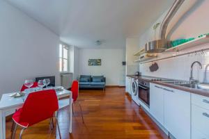 a kitchen with a table and red chairs in a room at Cozy Flat 500m from Affori FN! in Milan