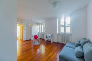 a living room with a blue couch and wooden floors at Cozy Flat 500m from Affori FN! in Milan