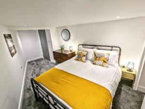 a bedroom with a large bed with a yellow blanket at Ramsgate Retreat - ultra modern 3 bed in Ramsgate