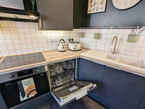 a kitchen with a dishwasher in the middle of a kitchen at Ramsgate Retreat - ultra modern 3 bed in Ramsgate