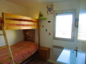 フロンティニャンにあるAppartement Grand Calypsoのベッドルーム(二段ベッド1組、窓付)