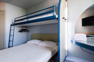 ein Schlafzimmer mit einem Etagenbett und ein Badezimmer in der Unterkunft ibis budget Lyon Villeurbanne in Villeurbanne
