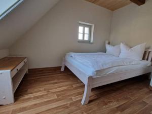 a bedroom with a white bed and a wooden floor at Erbgericht Putzkau in Putzkau