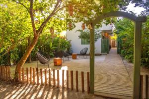 un arco que conduce a un patio con sillas y un árbol en Pousada Verde Mar, en Trancoso