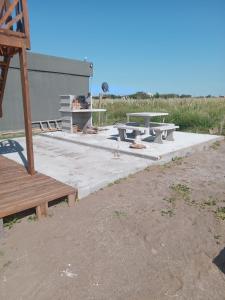 un grupo de mesas de picnic en una losa de hormigón en Leosanmareta en 