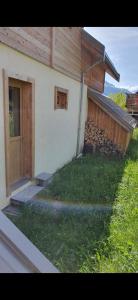 a house with a door and a yard with grass at Le Chalet de Lili in Névache