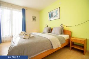 a bedroom with a large bed with two towels on it at Haus Haldahus by Arosa Holiday in Arosa