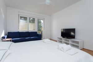 a white bedroom with a large bed and a blue couch at BEUS DOWNTOWN in Split