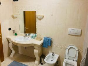 a bathroom with a sink and a toilet and a mirror at 1Dest - La Corte in Riva del Garda +11 photos