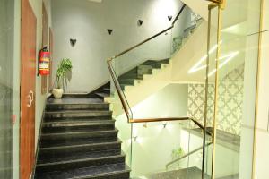 a staircase in a house with a glass railing at THE PARKQUEEN in Rohtak