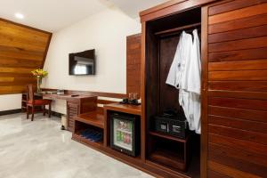ein Bad mit einem Waschbecken und einem Schreibtisch sowie ein Zimmer in der Unterkunft Blanc Smith Hotel in Siem Reap