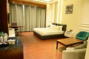 a hotel room with a bed and a couch at THE PARKQUEEN in Rohtak