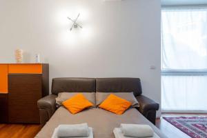 a couch with two orange pillows in a living room at ARCIVESCOVADO 7 in Turin