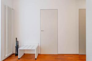 a white bench sitting in front of a white wall at ARCIVESCOVADO 7 in Turin