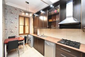 a kitchen with wooden cabinets and a counter top at Prime Apartment 2 Bedroom In The Center Of Yerevan,Near Republic Square in Yerevan