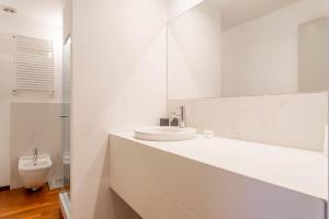 a white bathroom with a sink and a toilet at ARCIVESCOVADO 7 in Turin
