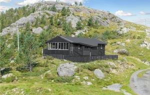a black cabin on top of a mountain at Beautiful Home In Bjerkreim With House A Mountain View in Bjerkreim