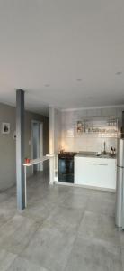 a large kitchen with white cabinets and a stove at COMPLEJO LA ISLA MAR CHIQUITA in Balneario Mar Chiquita