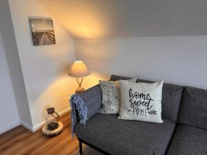 uma sala de estar com um sofá e um candeeiro em Ferienwohnung Deichblick em Emden