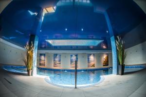 a large building with a swimming pool at night at Hotel Szafir in Jastrzębia Góra