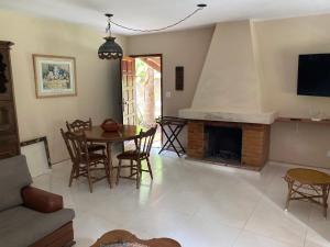 een woonkamer met een tafel en een open haard bij Aconchegante casa nas montanhas de Serra Negra in Serra Negra