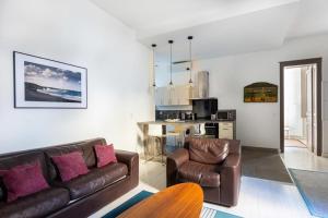 un soggiorno con divano e sedie e una cucina di Magnifique Appartement avec climatisation en Hyper Centre de Bordeaux a Bordeaux